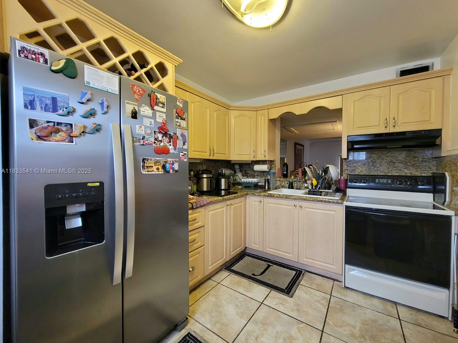 11 Olive Drive, Unit J Hialeah, FL 33010 - Photo 6 of 20 a kitchen with stainless steel appliances granite countertop a refrigerator and a stove top oven