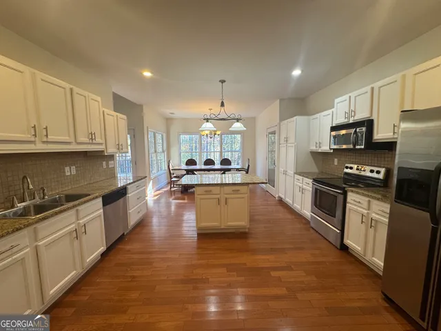 a kitchen with center island and stainless steel appliances