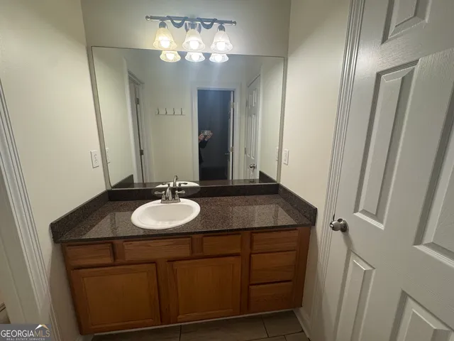 an empty room with a chandelier fan and windows