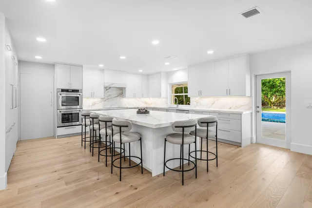 a dining room with couches chairs and kitchen view