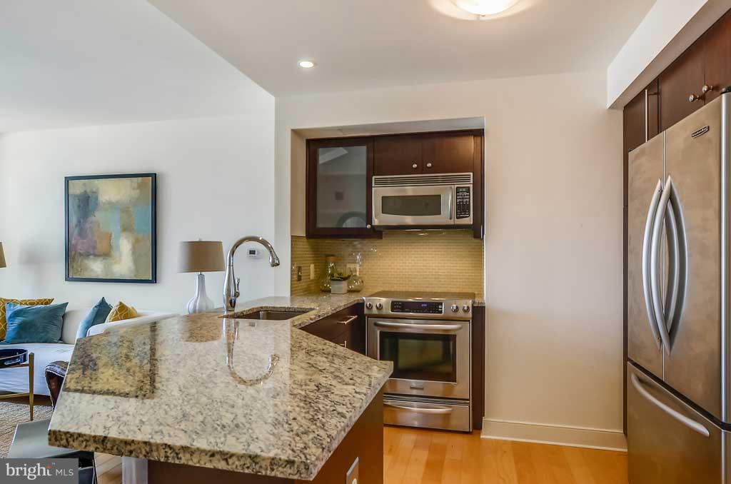 675 President Street, Unit 2607 Baltimore, MD 21202 - Photo 8 of 18 a kitchen with stainless steel appliances granite countertop a sink and a refrigerator