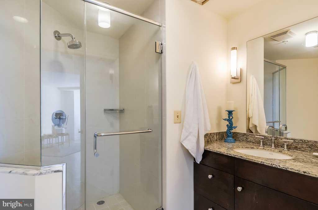675 President Street, Unit 2607 Baltimore, MD 21202 - Photo 10 of 18 a bathroom with a granite countertop shower sink and mirror
