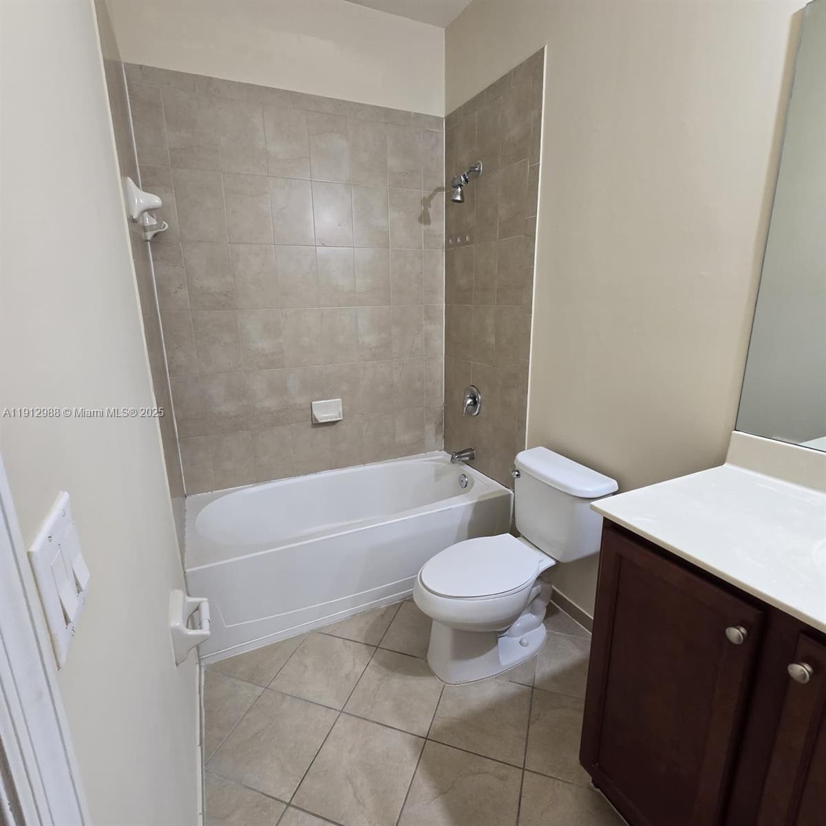 9051 Southwest 227th Street, Unit 3 Cutler Bay, FL 33190 - Photo 20 of 33 a bathroom with a toilet a sink and a bathtub