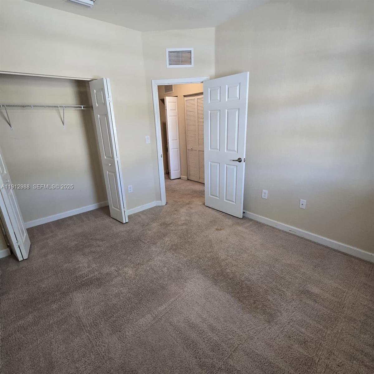 9051 Southwest 227th Street, Unit 3 Cutler Bay, FL 33190 - Photo 28 of 33 an empty room with closet and wooden door