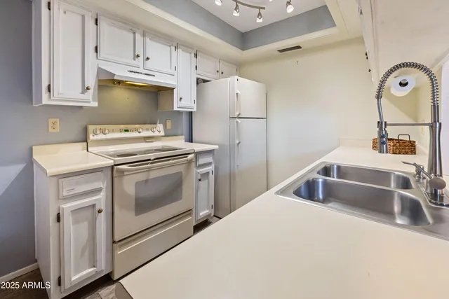 a kitchen with white cabinets and white appliances