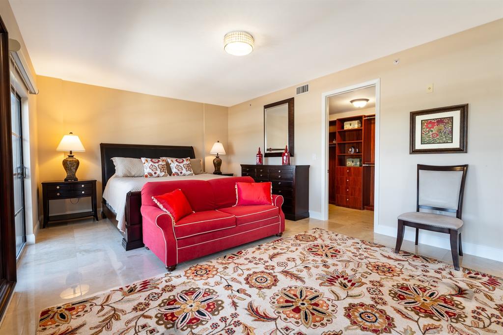 2401 North Ocean Boulevard, Unit 403 Fort Lauderdale, FL 33305 - Photo 16 of 32 a bedroom with a bed and a lamp on dresser