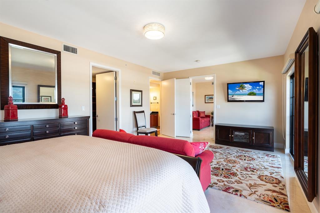 2401 North Ocean Boulevard, Unit 403 Fort Lauderdale, FL 33305 - Photo 18 of 32 a bedroom with a bed and a large mirror on the dresser