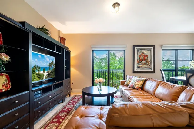 a dining room with furniture a flat screen tv and a floor to ceiling window