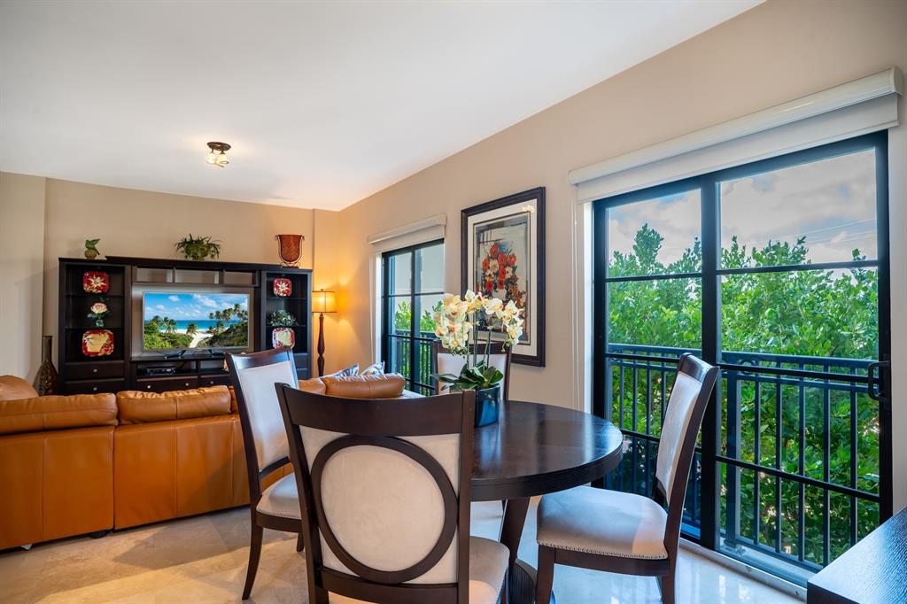 2401 North Ocean Boulevard, Unit 403 Fort Lauderdale, FL 33305 - Photo 6 of 32 a dining room with furniture a flat screen tv and a floor to ceiling window