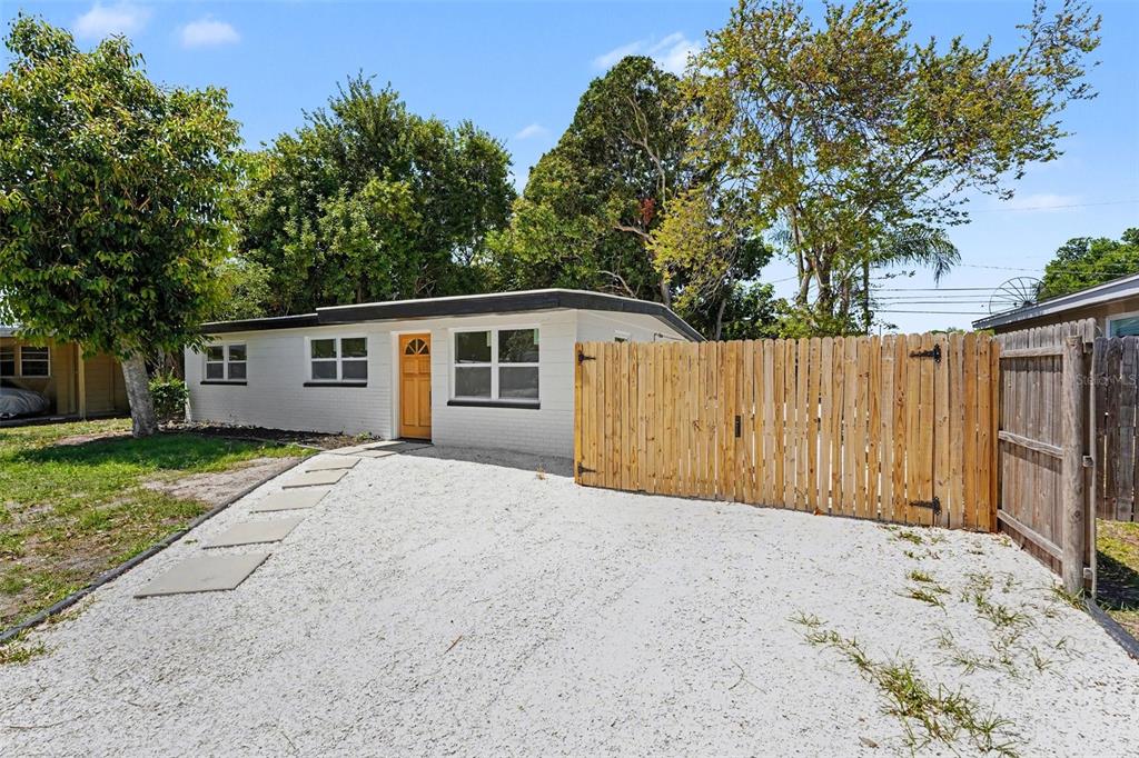 a view of backyard with large trees and wooden fence