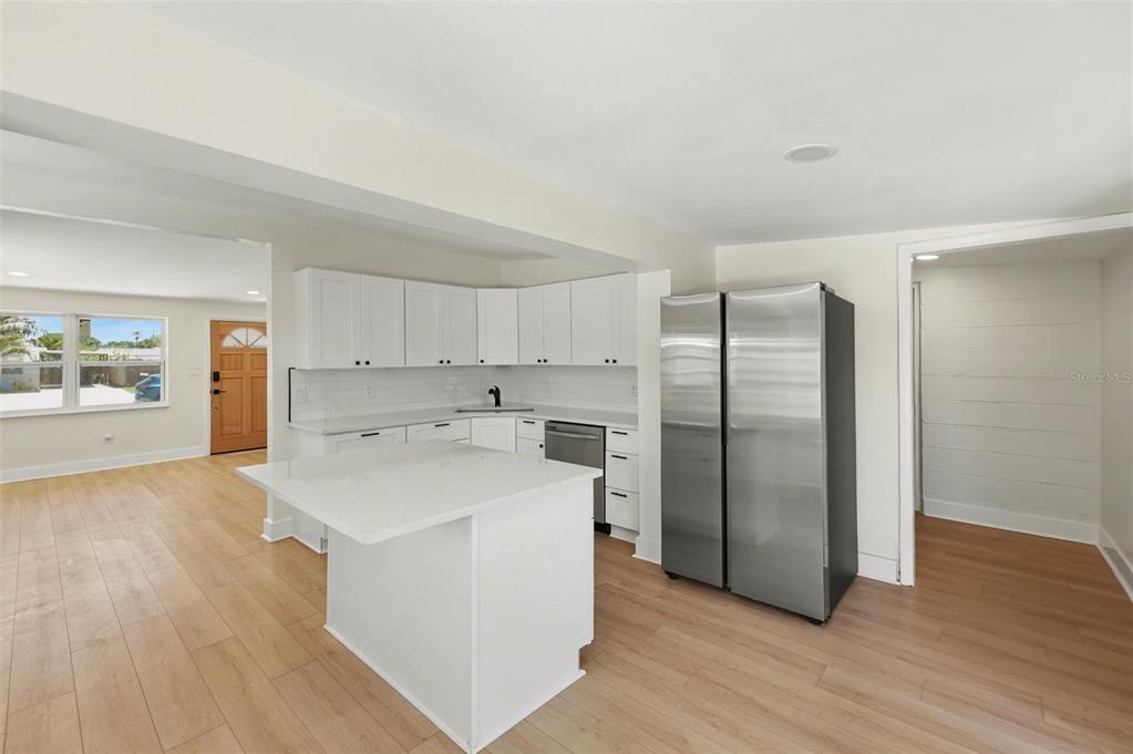 9482 Crestview Street Seminole, FL 33772 - Photo 11 of 35 a kitchen with stainless steel appliances a refrigerator and wooden floor