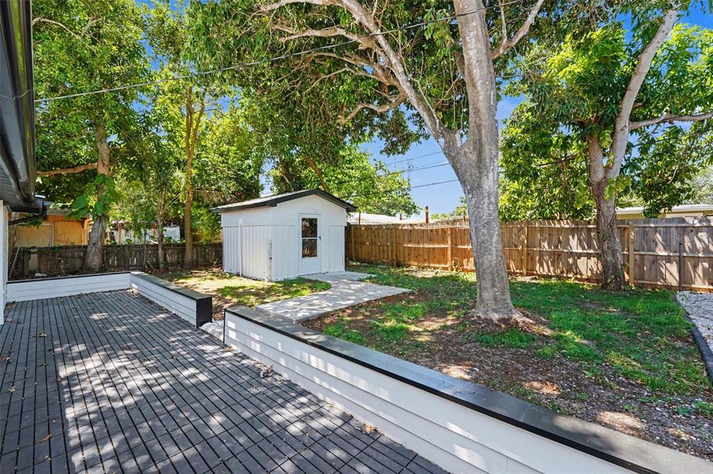 9482 Crestview Street Seminole, FL 33772 - Photo 31 of 35 a view of a backyard with wooden fence and a large tree