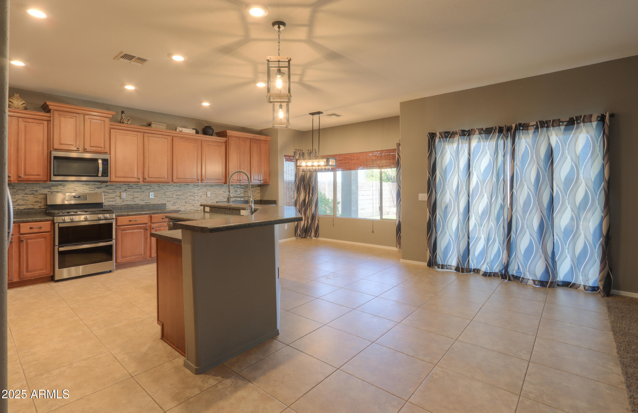 44254 Adobe Circle Maricopa, AZ 85139 - Photo 16 of 71 a kitchen with stainless steel appliances granite countertop a stove top oven a sink and a refrigerator