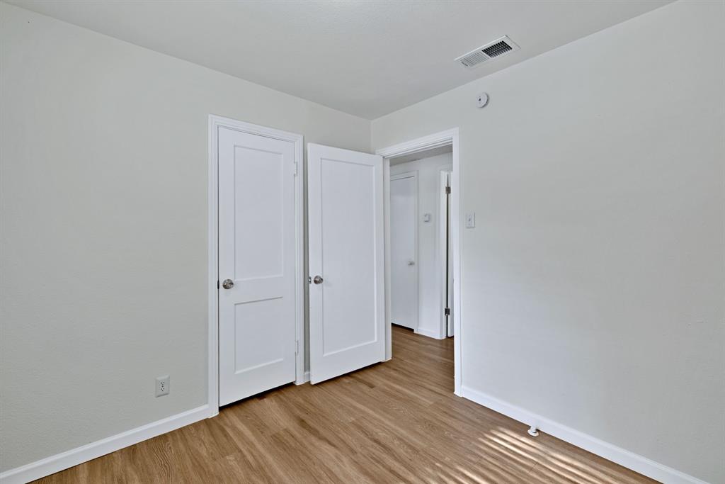 613 Cheyenne Road Dallas, TX 75217 - Photo 18 of 28 Light-filled interior featuring wood-finish flooring, white baseboards, and neutral wall paint