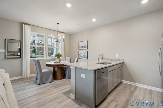 a kitchen with kitchen island a sink a stove a refrigerator cabinets and wooden floor