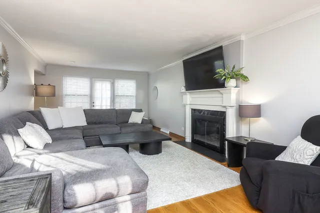 a living room with furniture a fireplace and a flat screen tv