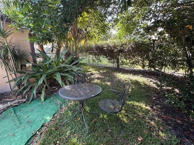 a view of a backyard with plants and a fountain