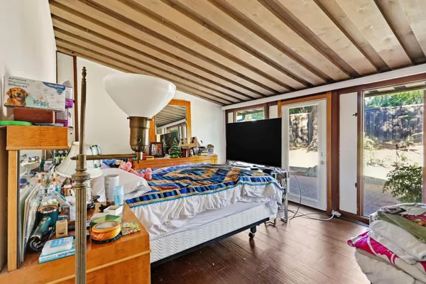 a living room with patio furniture and a flat screen tv