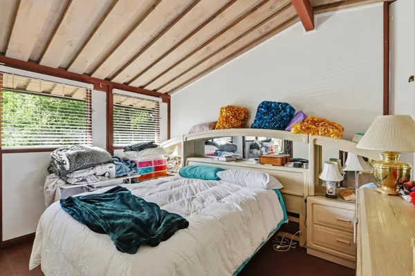 a bedroom with furniture and a large window