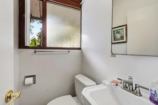 a bathroom with a toilet sink and mirror