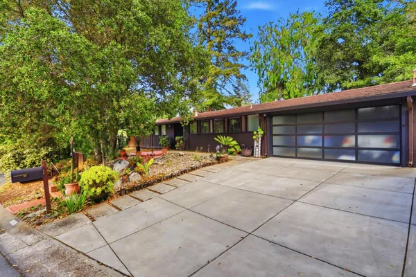 a view of a house with a yard and potted plants
