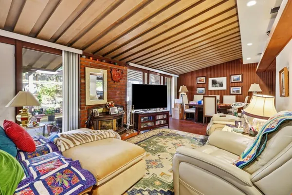a living room with furniture a flat screen tv and a large window