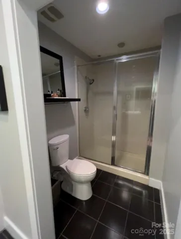 a bathroom with a toilet and a shower