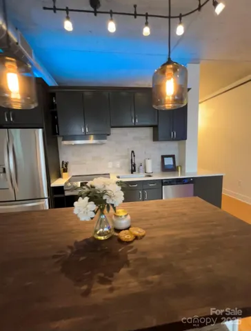 a kitchen with stainless steel appliances wooden floor dining table chairs and a fireplace