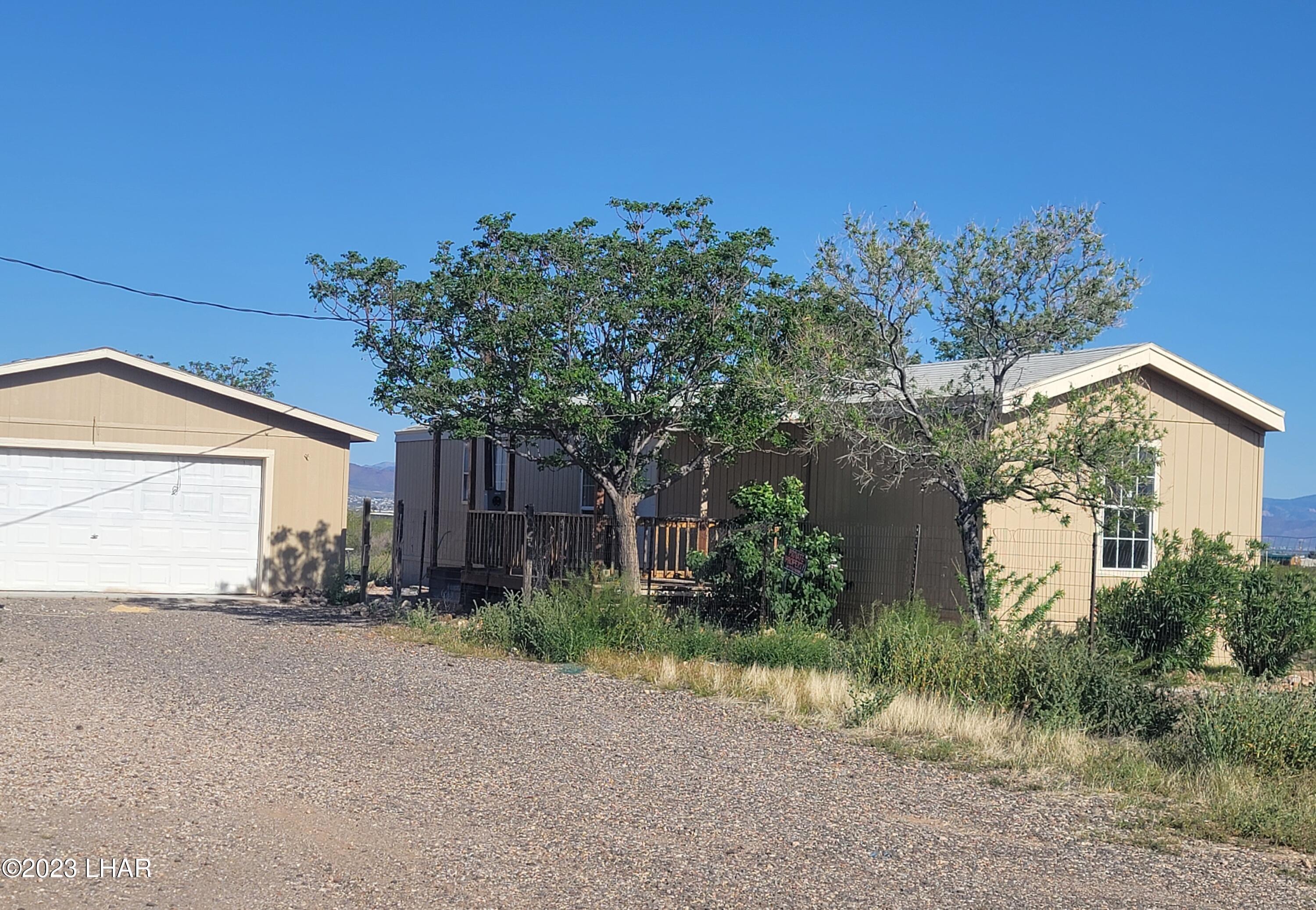 4944 Elgin Road Golden Valley, AZ 86413 - Photo 1 of 14 a row of palm trees and a house in the background