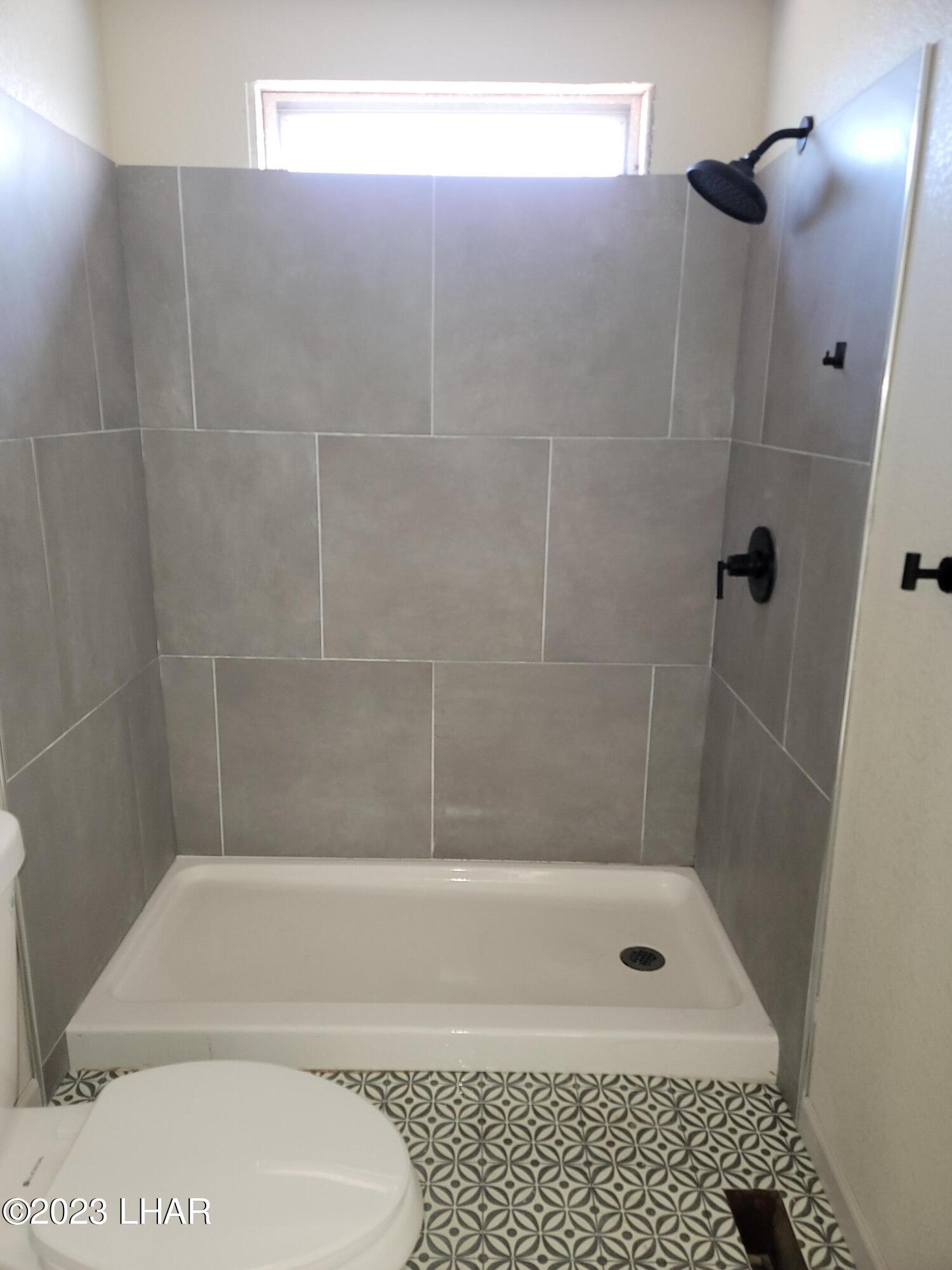 4944 Elgin Road Golden Valley, AZ 86413 - Photo 11 of 14 a bathroom with a shower and a toilet