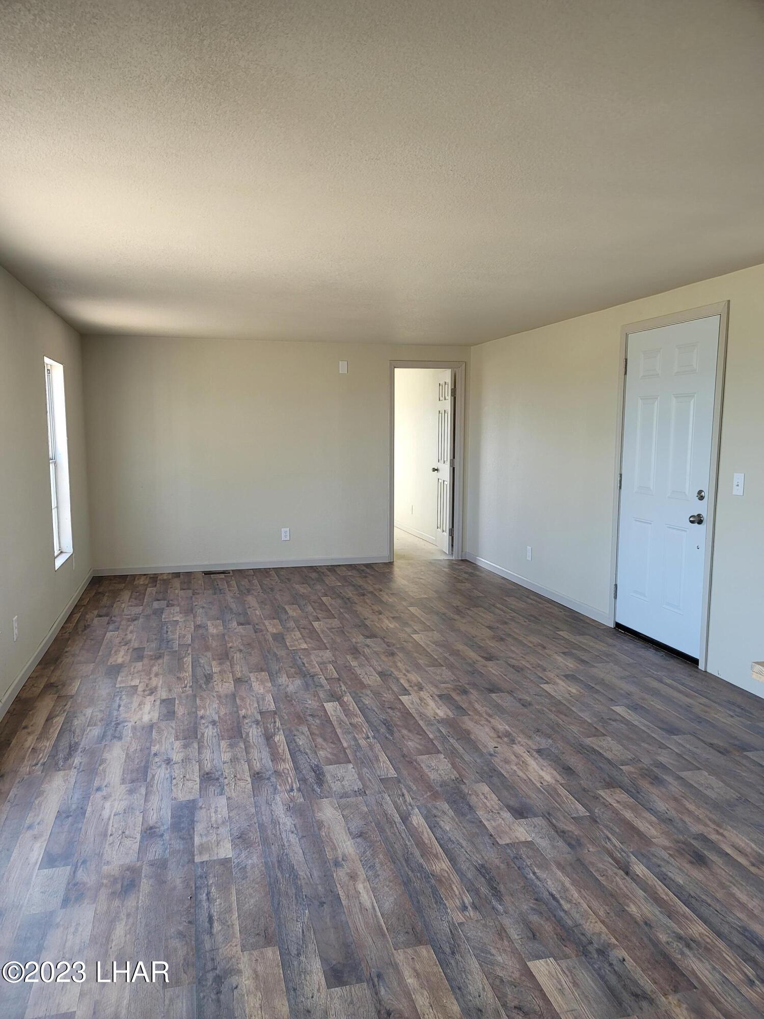 4944 Elgin Road Golden Valley, AZ 86413 - Photo 5 of 14 wooden floor in an empty room with a window