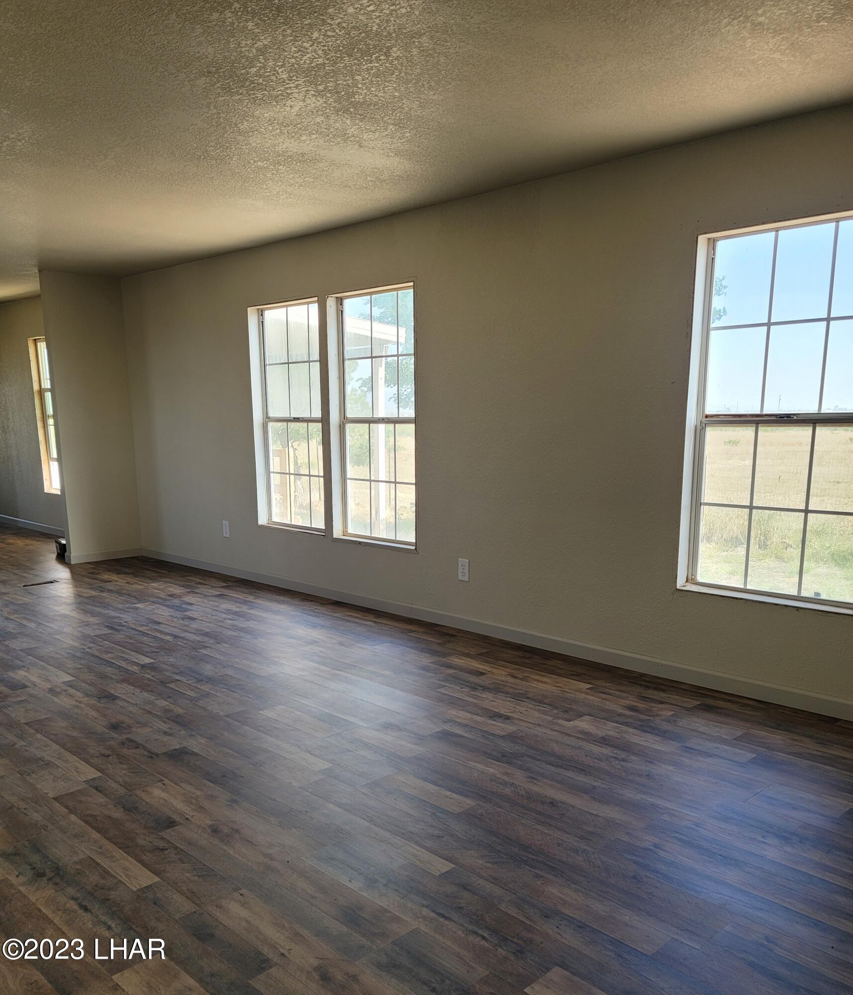 4944 Elgin Road Golden Valley, AZ 86413 - Photo 6 of 14 an empty room with wooden floor and windows