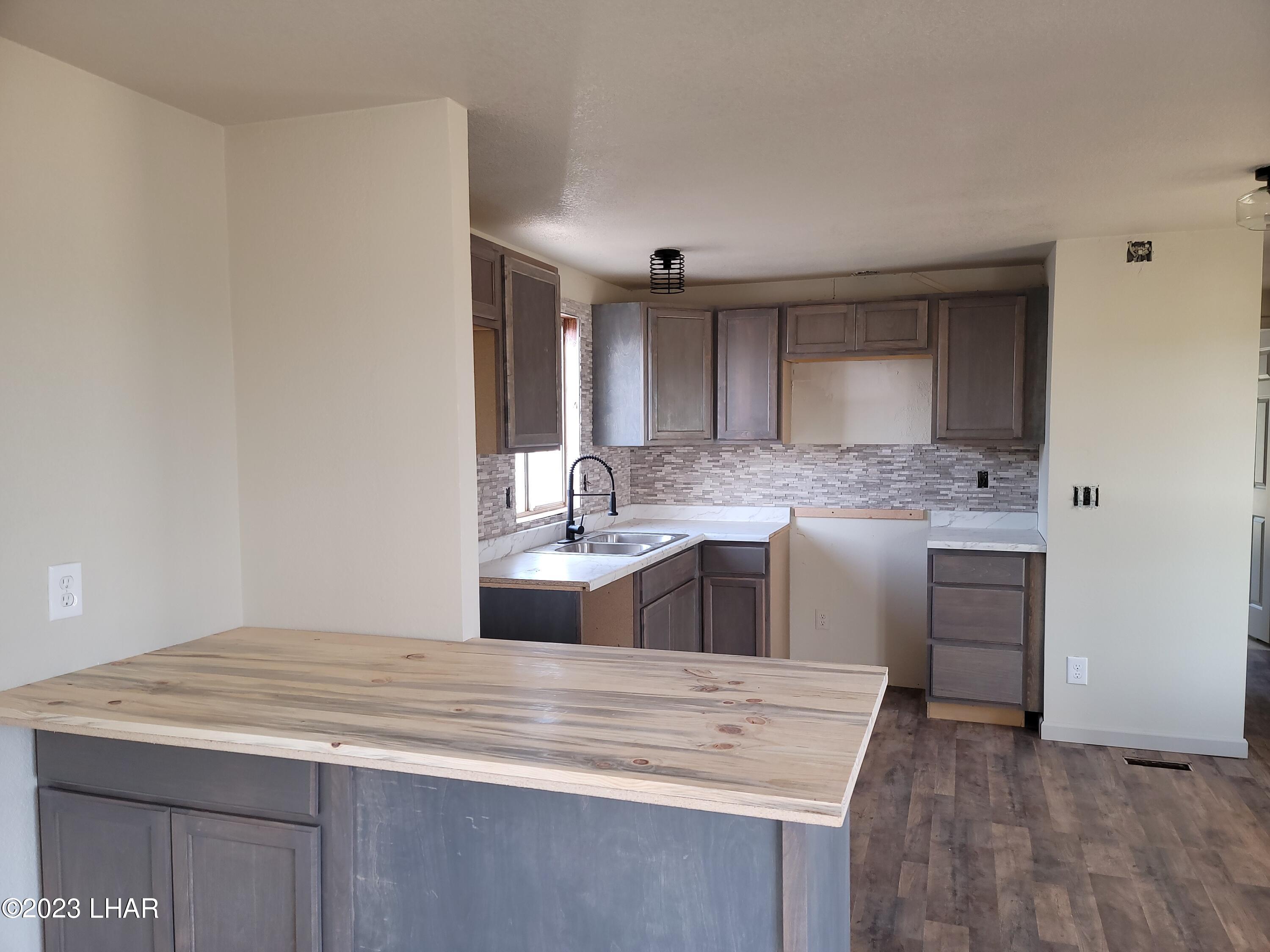 4944 Elgin Road Golden Valley, AZ 86413 - Photo 8 of 14 a kitchen with kitchen island a sink appliances and cabinets