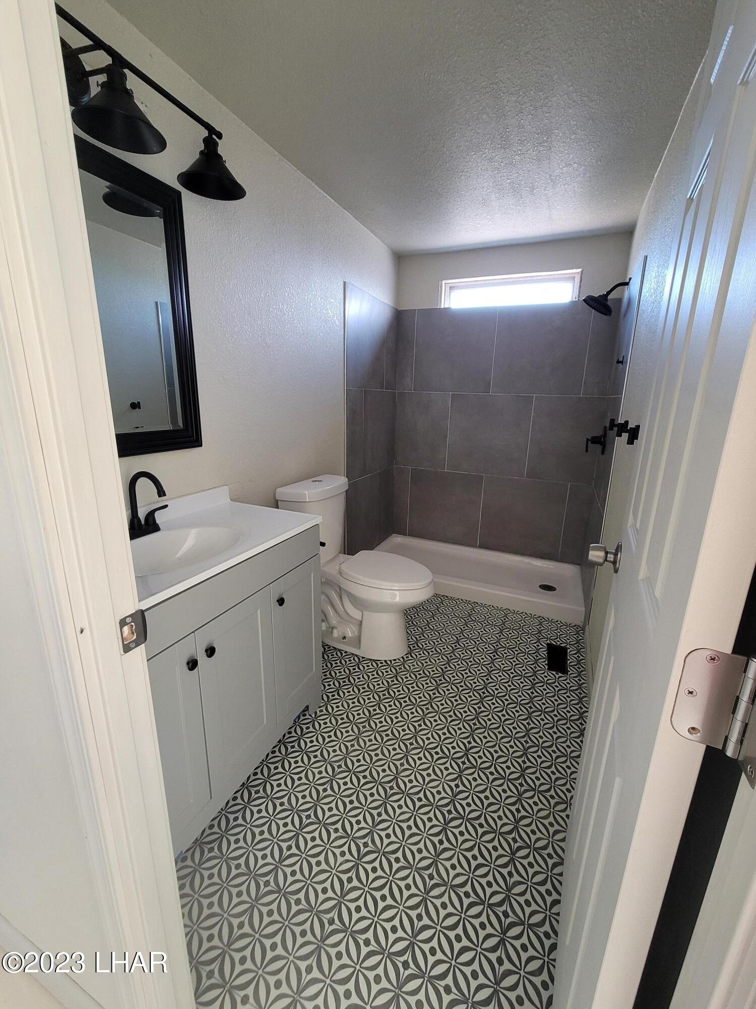 4944 Elgin Road Golden Valley, AZ 86413 - Photo 10 of 14 a bathroom with a sink a toilet and shower