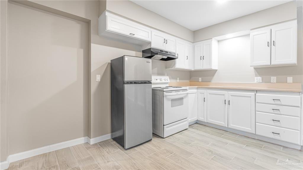 712 Toronto Avenue, Unit 2 McAllen, TX 78503 - Photo 3 of 12 a kitchen with white cabinets and white appliances