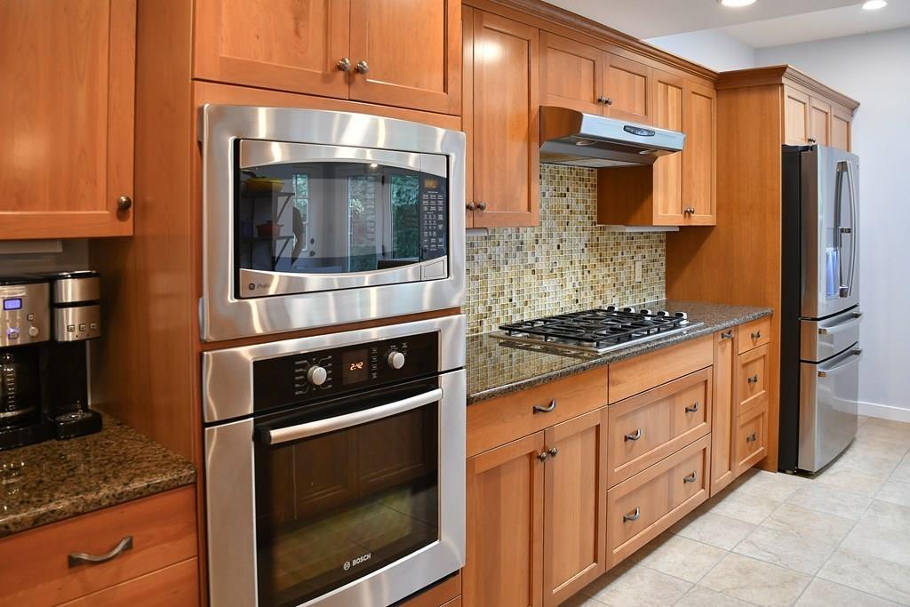 210 Haynes Road Sudbury, MA 01776 - Photo 22 of 42 a kitchen with stainless steel appliances granite countertop a stove microwave and refrigerator