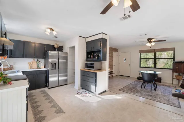 a kitchen with stainless steel appliances kitchen island granite countertop a refrigerator and a stove top oven