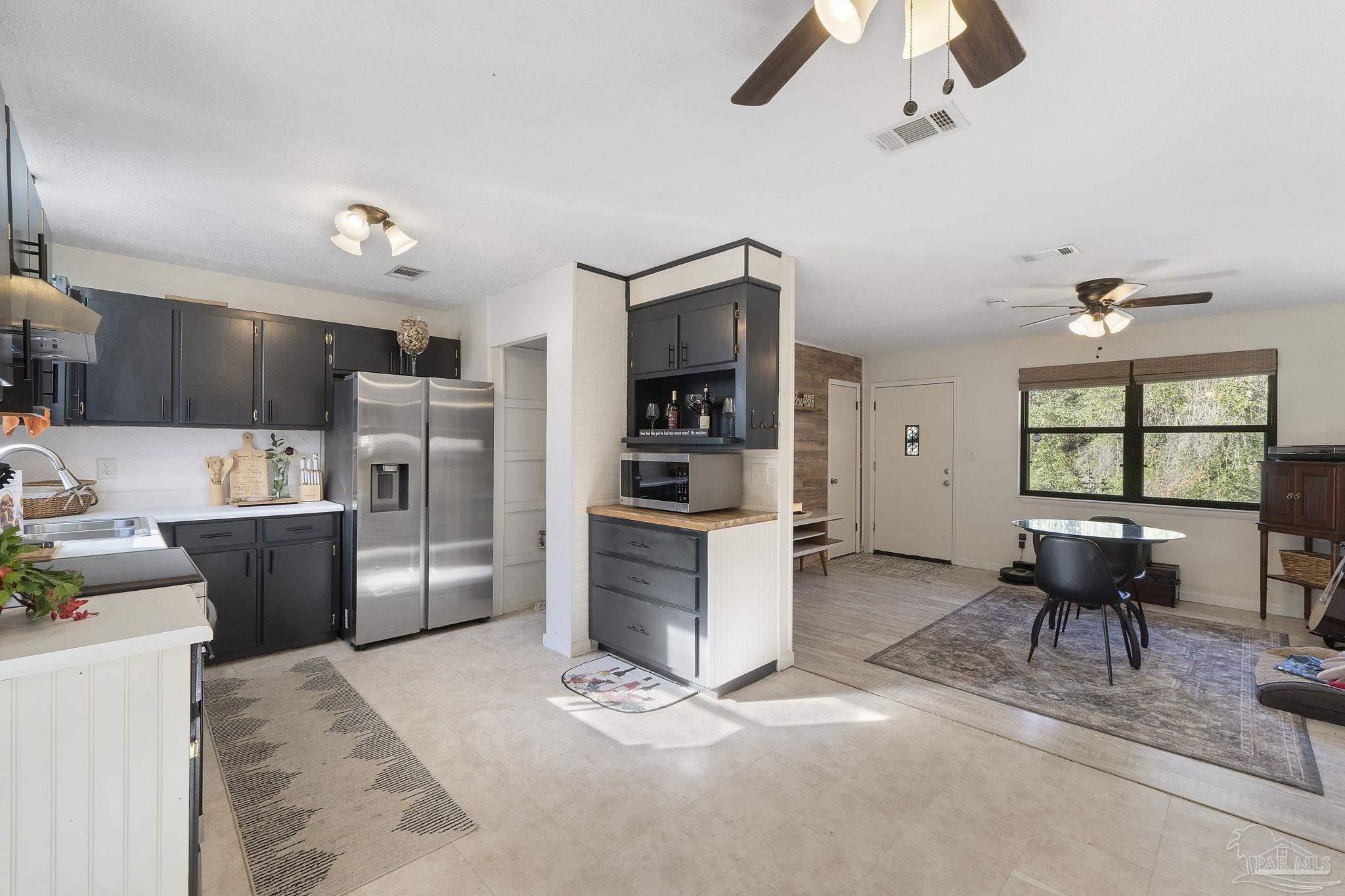 465 Ronda Street Pensacola, FL 32534 - Photo 13 of 48 a kitchen with stainless steel appliances kitchen island granite countertop a refrigerator and a stove top oven