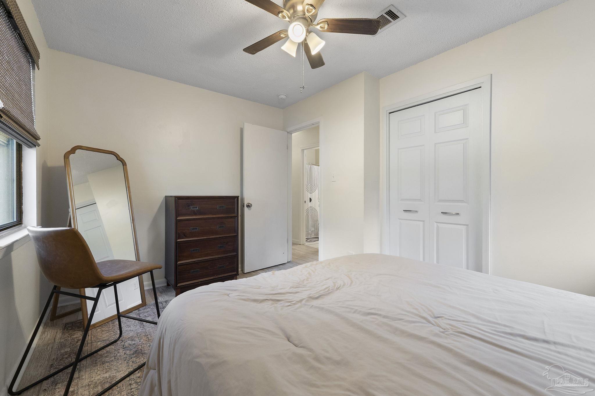 465 Ronda Street Pensacola, FL 32534 - Photo 20 of 48 a bedroom with a bed and a chair with the wooden floor