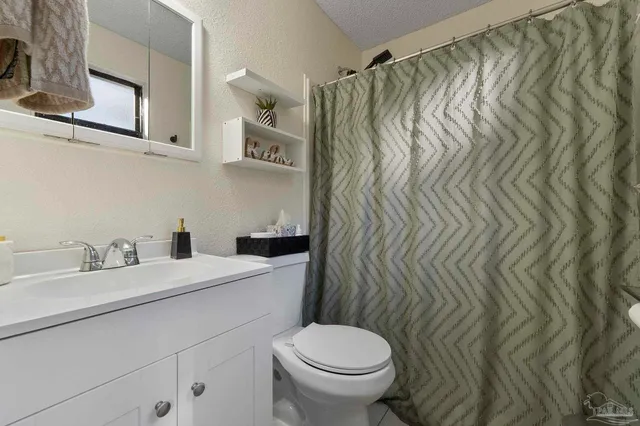 a bathroom with a sink a toilet and shower curtain