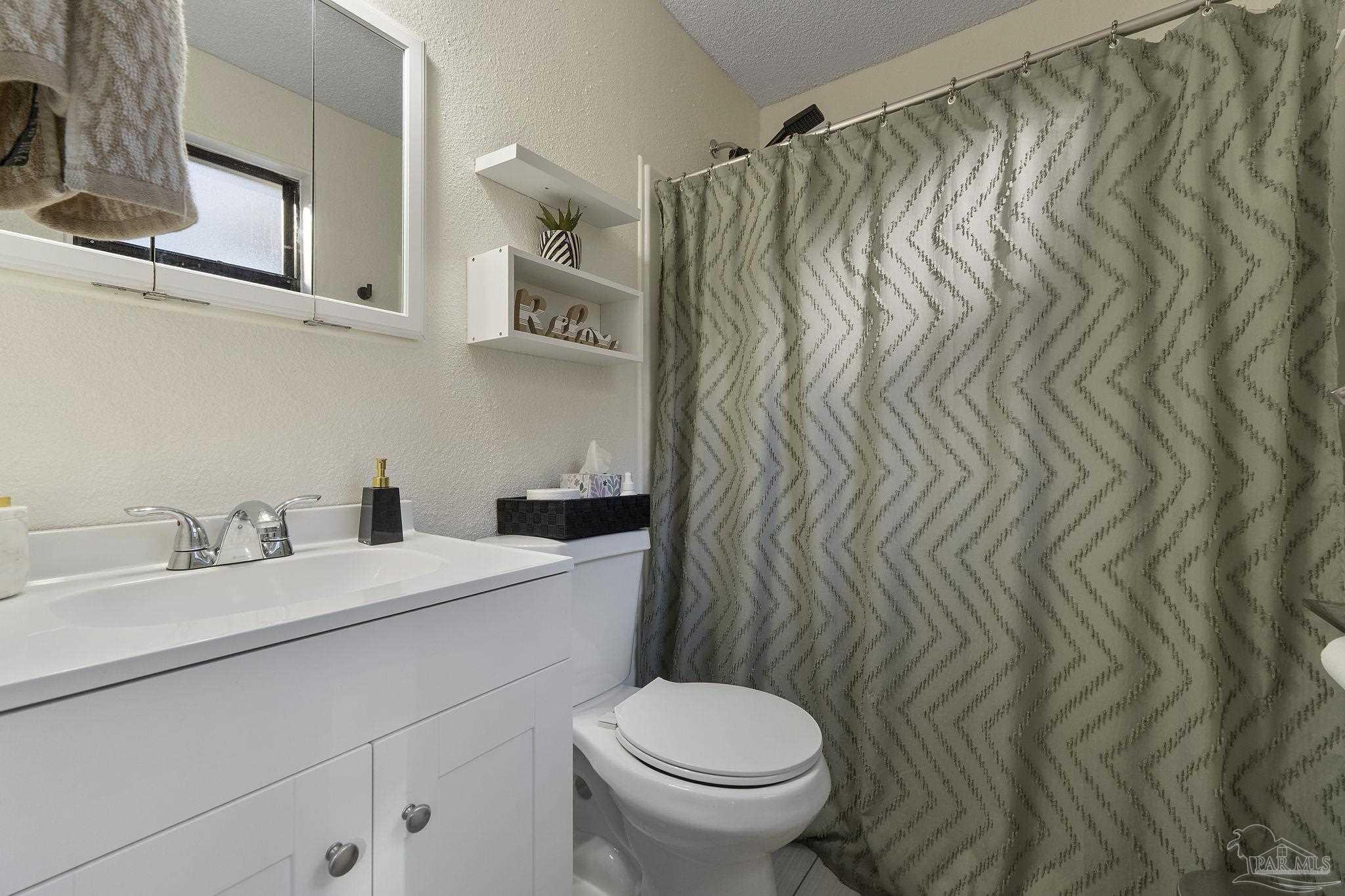465 Ronda Street Pensacola, FL 32534 - Photo 24 of 48 a bathroom with a sink a toilet and shower curtain