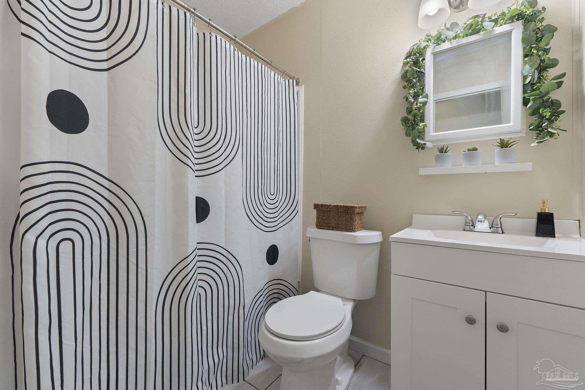 465 Ronda Street Pensacola, FL 32534 - Photo 25 of 48 a bathroom with a sink a toilet mirror and vanity
