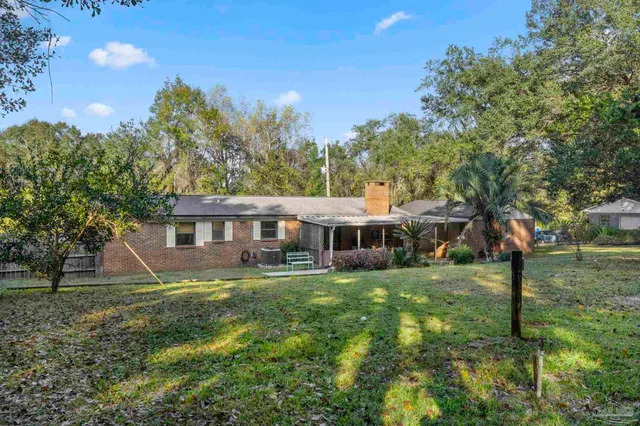 a view of a lush green field with lots of trees