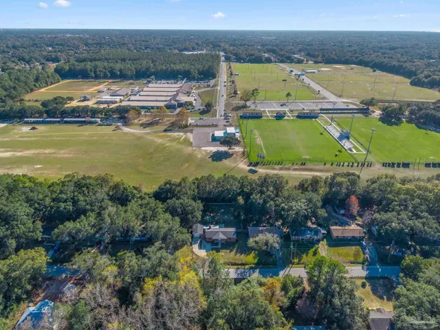 an aerial view of a house with a yard and lake view