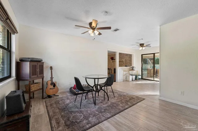 a dining room with furniture a chandelier and wooden floor