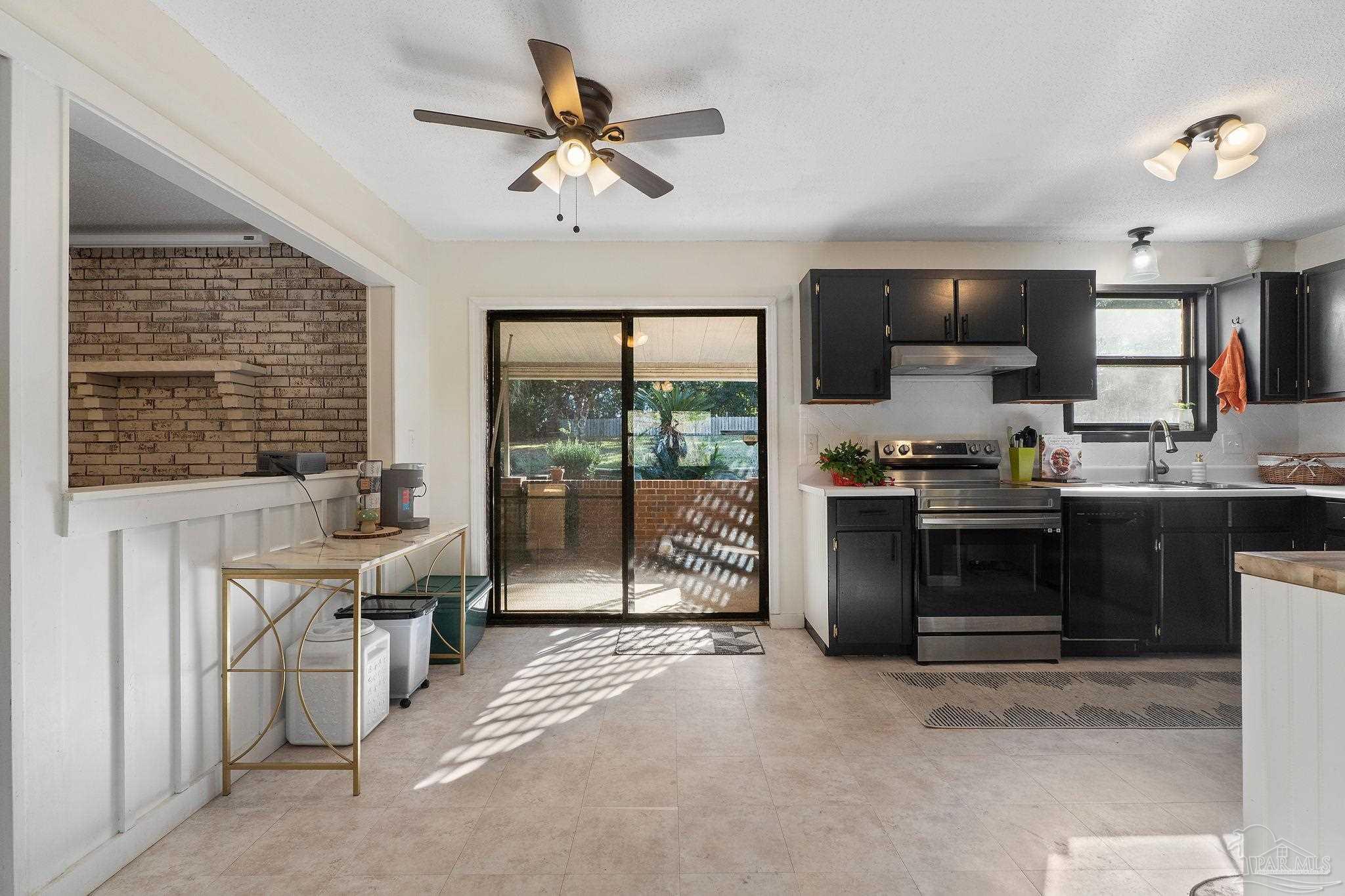 465 Ronda Street Pensacola, FL 32534 - Photo 8 of 48 a kitchen with stainless steel appliances kitchen island granite countertop a stove top oven a sink a dining table and chairs