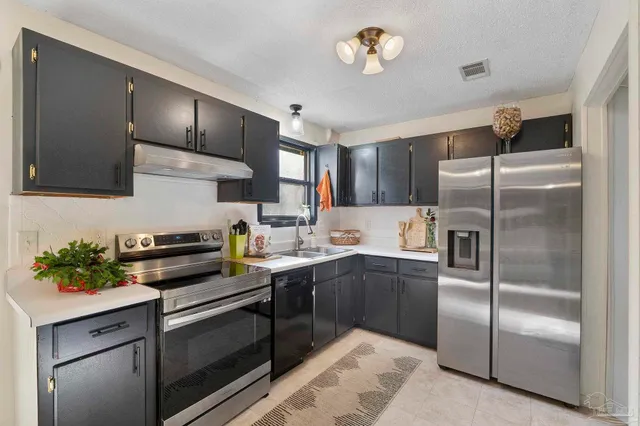 a kitchen with cabinets stainless steel appliances and a counter space