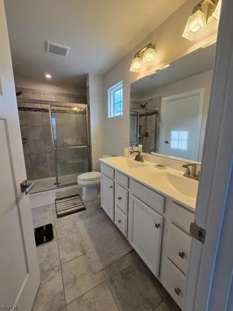 a bathroom with a double vanity sink toilet and shower