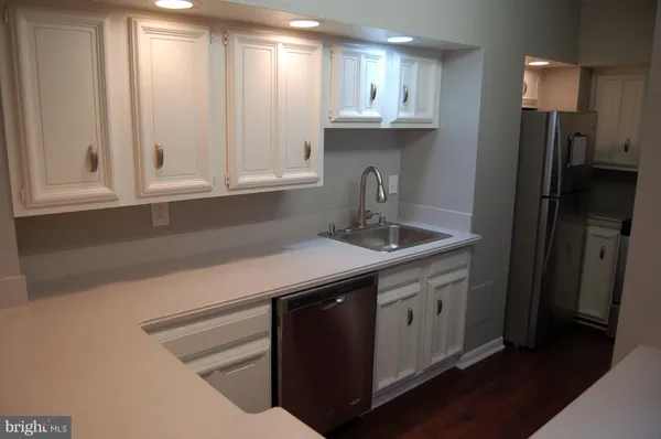 a kitchen with stainless steel appliances granite countertop a sink a refrigerator and a granite counter tops