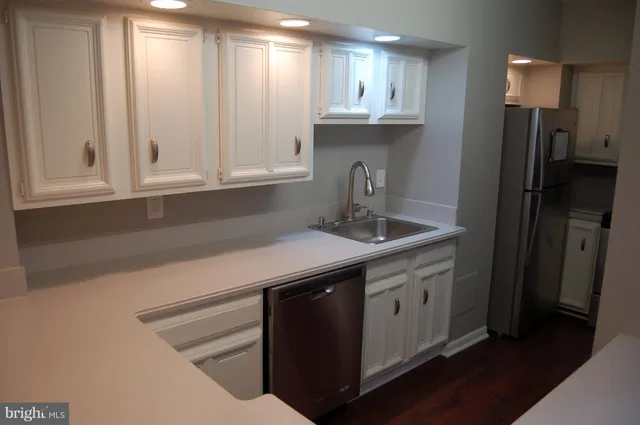 a kitchen with stainless steel appliances granite countertop a sink a refrigerator and a granite counter tops